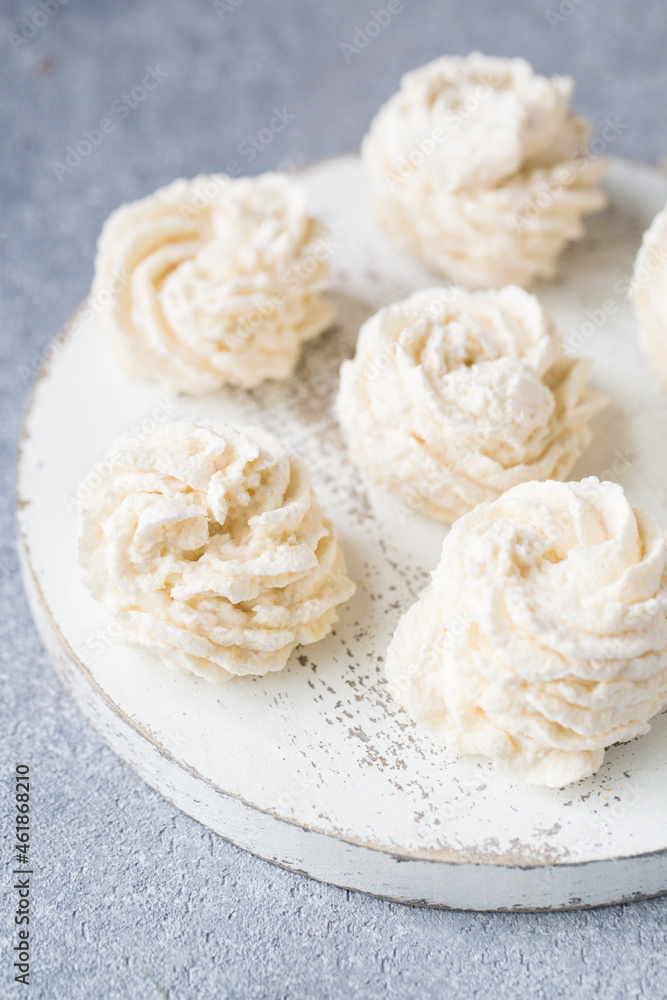 White marshmallow on a wooden board on a light background