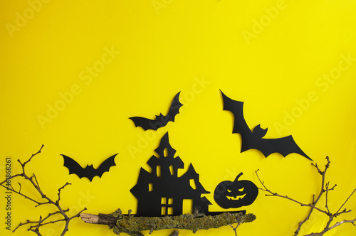 Halloween and decoration concept - bats, pumpkins, gloomy paper house, gloomy black tree branches on a yellow background. Folded paper origami art.
Halloween background with cut out
bats and other dec