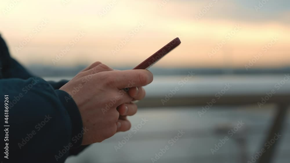 Close up of male hands holding mobile and typing messages Close up of male hands holding mobile and typing messages