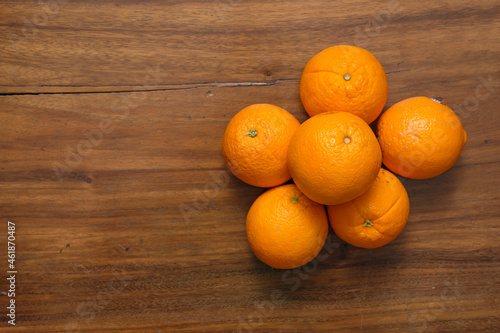 Fresh organic Oranges on the brown wooden table. Navel Oranges group freshly picked. Horizontal composition. Top view.