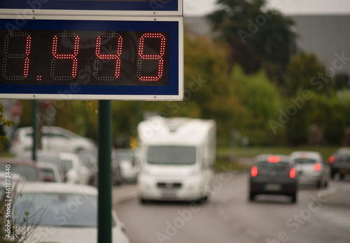 LED display board with gasoline price and blurred cars in the background