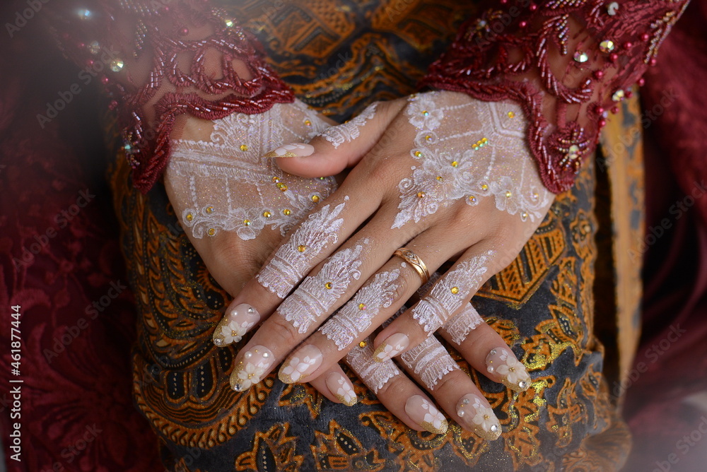 Traditional Javanese Women's Hands wearing henna and rings. Hands with beautiful Henna. new fullhand style mehndi. Close up view of Bride showing mehndi jewelry. mehendi painted on girl's hand.