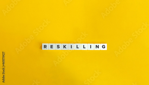 Reskilling banner and concept. Block letter tiles on bright orange background. Minimal aesthetics. photo