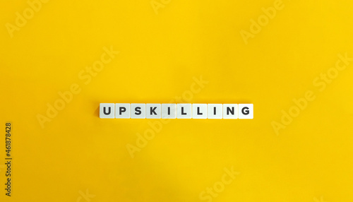 Upskilling banner and concept. Block letter tiles on bright orange background. Minimal aesthetics. photo