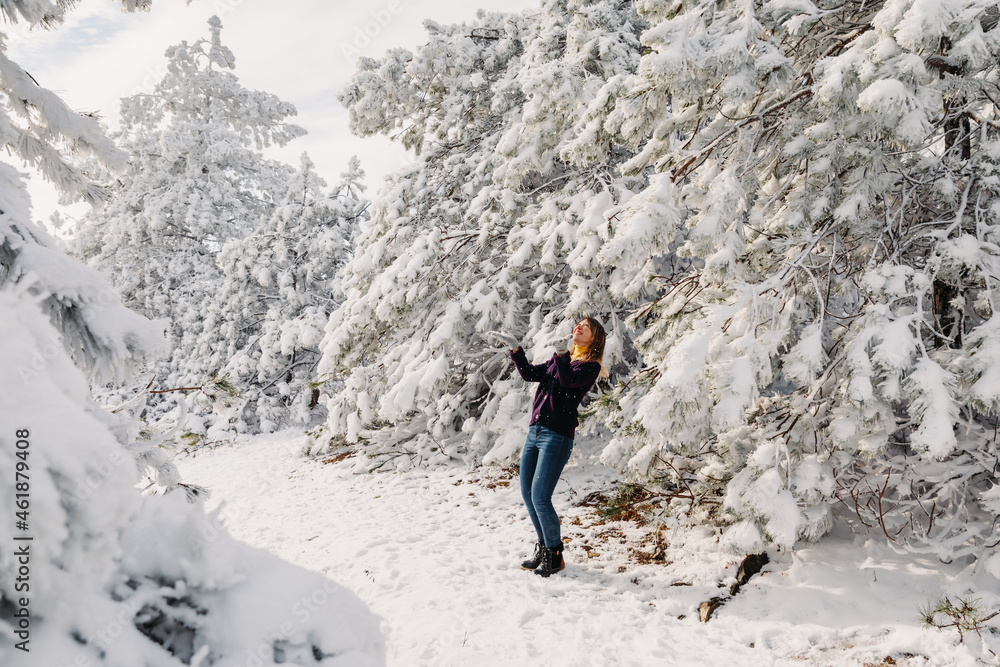 Woman in snowy winter forest. Happy woman posing in Christmas
