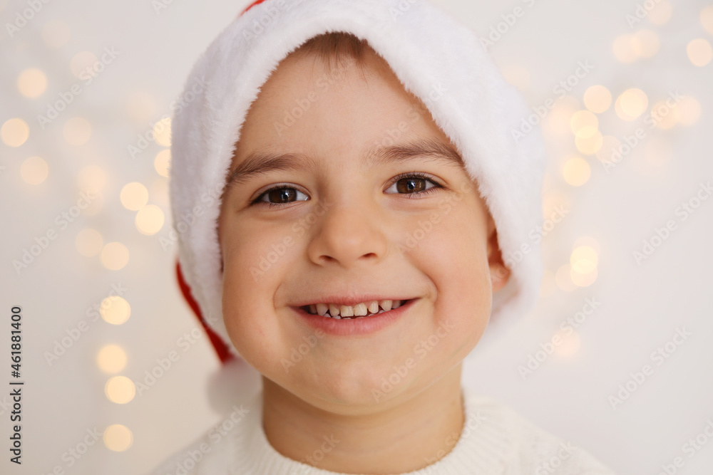 Smiling little boy with Christmas lights on the white background. Happy child, Christmas celebration, Xmas time.