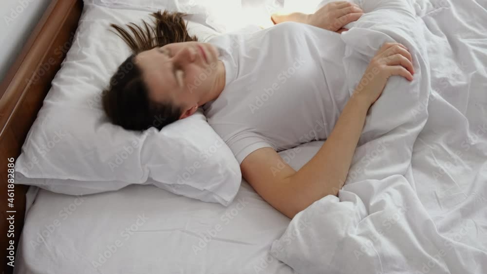 Side view of displeased annoyed young female rolling around in uncomfortable bed, feeling irritated of bad mattress or linen, suffer from insomnia bad dreams problem trying can not sleep concept Side view of displeased annoyed young female rolling around in uncomfortable bed, feeling irritated of bad mattress or linen, suffer from insomnia bad dreams problem trying can not sleep concept