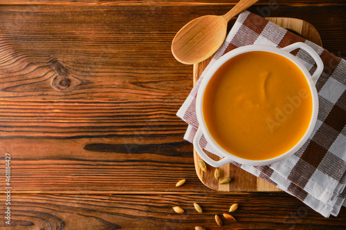 Homemade pumpkin soup with cream on wooden background