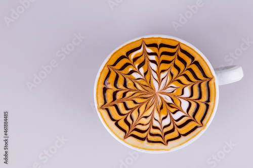 Hot cappuccino coffee with nice milk pattern on grey background