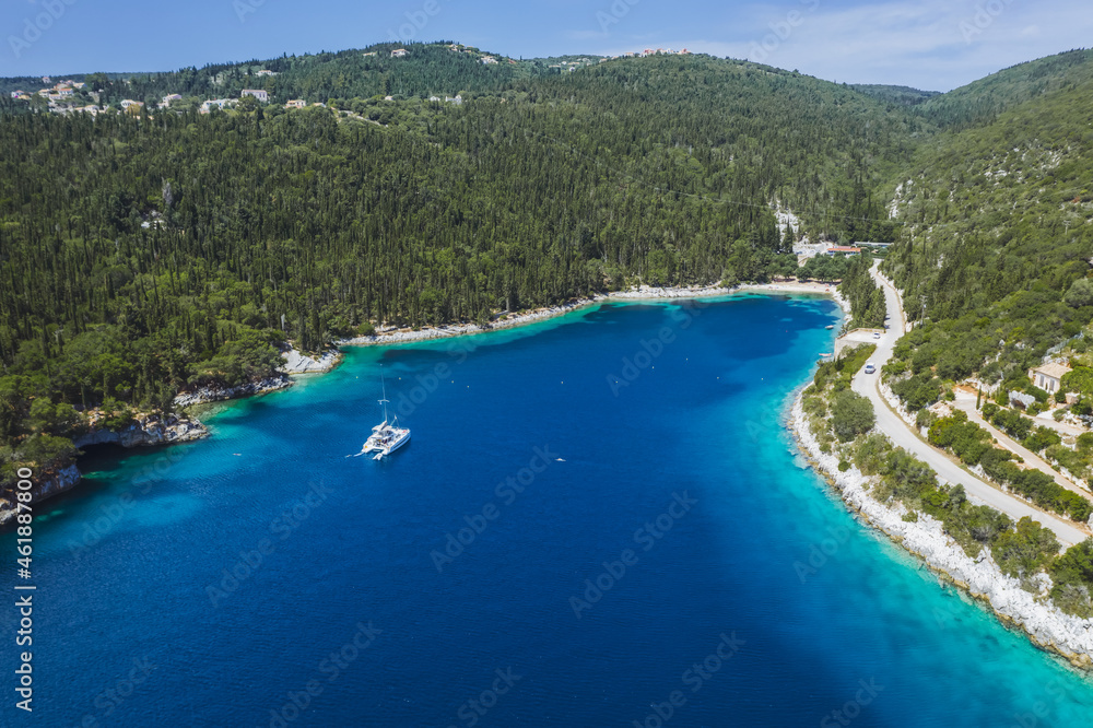 Panoramic aerial view of Foki Beach and sailing yacht boats moored in turquoise bay. Fiskardo, Kefalonia island, Greece