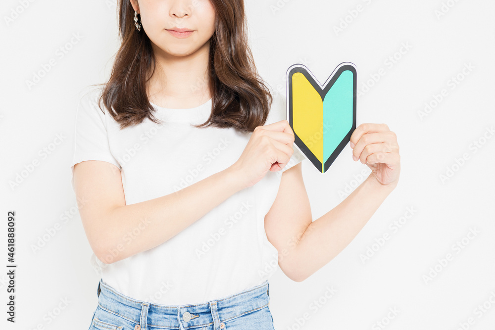 初心者マークを持っているTシャツを着た若い女性