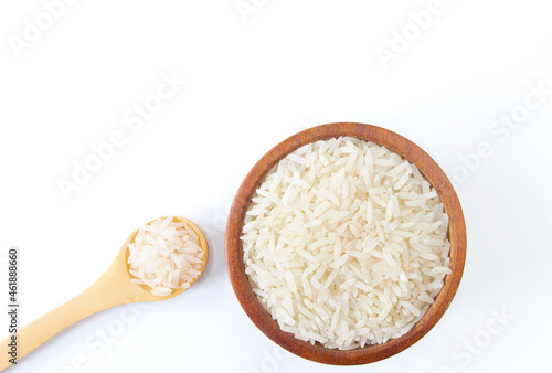 Top view of uncooked dry rice in wooden bowl isolated on white.