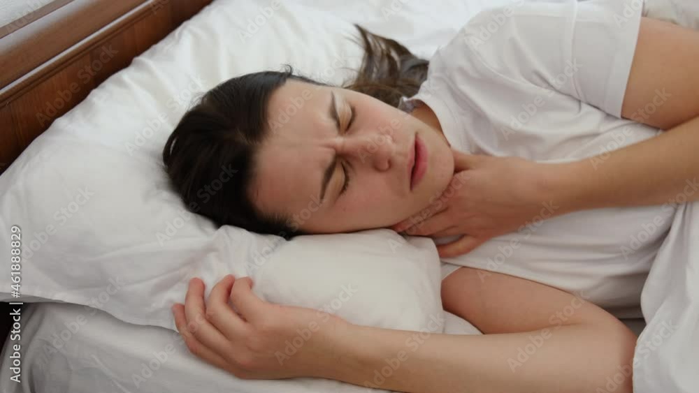 Unhealthy young millennial female touch neck hard to swallow having discomfort or painful feeling lying on bed at home, unwell sad girl suffering from angina, sore throat, experience loss of voice Unhealthy young millennial female touch neck hard to swallow having discomfort or painful feeling lying on bed at home, unwell sad girl suffering from angina, sore throat, experience loss of voice