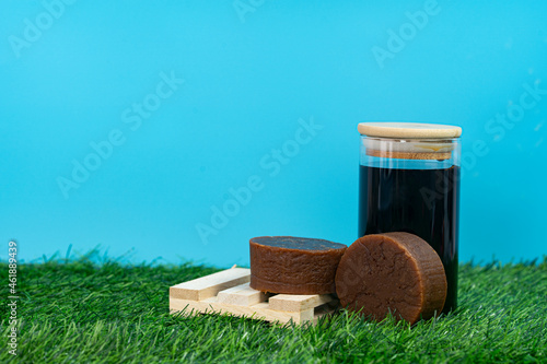 A couple of palm sugar with a jar of liquified palm sugar. Selective focus points. Blurred background  photo