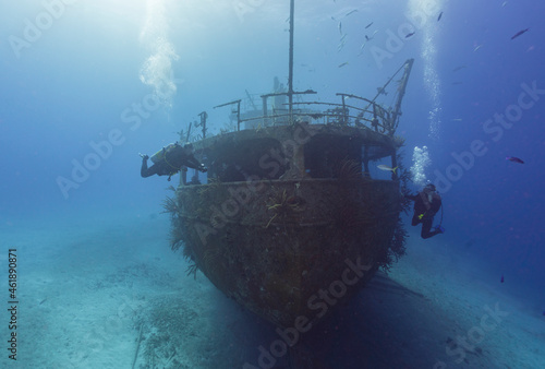 SCUBA divers exploring a caribbean ship wreck