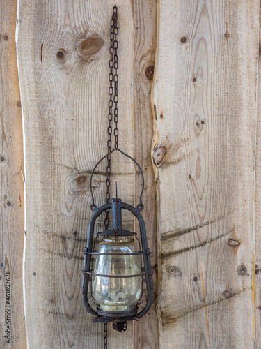 Old petroleum lamp hanging on wooden wall