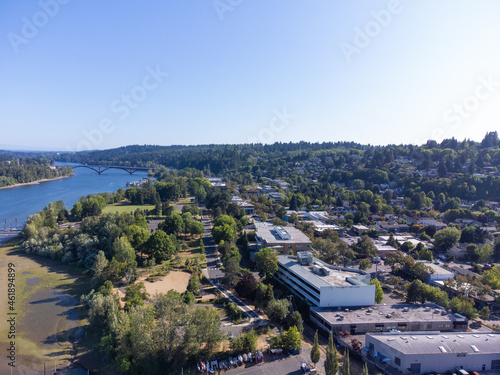 Small town near the river. Mountain range, lots of greenery. Aerial photography. Calm scenes. Beauty of nature. Postcard, booklet, advertising tourist routes.