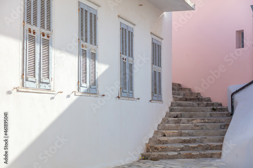 Stonestairs empty between whitewashed house and pink wall at Ermoupoli Syros island Cyclades Greece photo