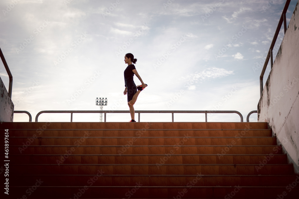 running woman stretching during morning exercise on the stadium stairs health care concept running woman stretching during morning exercise on the stadium stairs health care concept