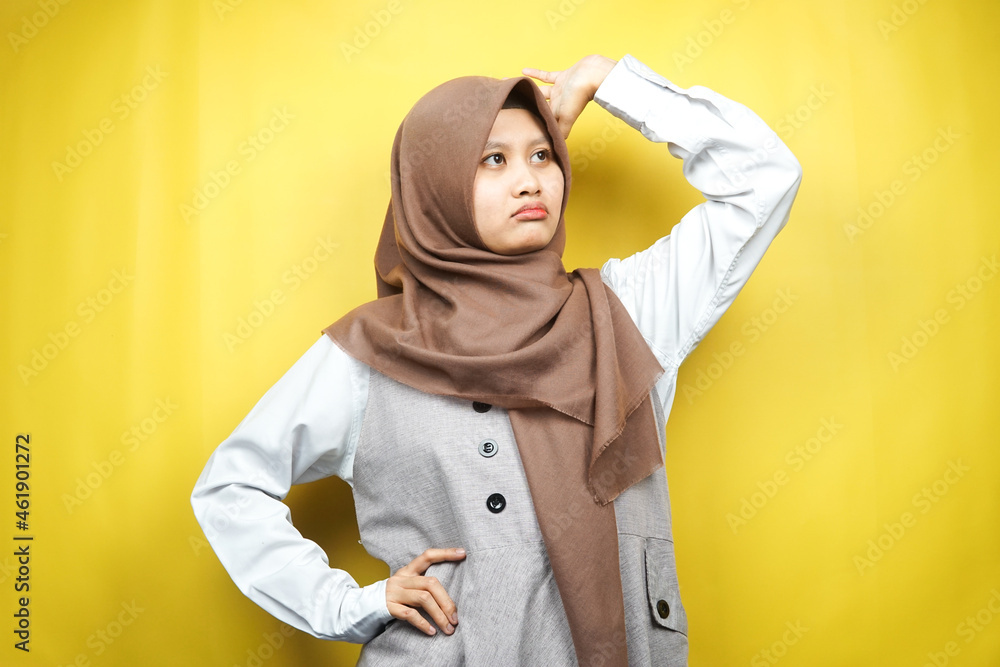 Beautiful young asian muslim woman stressed, dizzy, have a problem, feeling depressed, with hands holding head isolated on yellow background