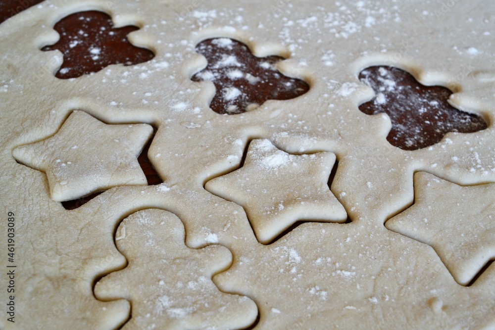 Christmas cookie dough stretched and cut with gingerbread man and stars molds Christmas cookie dough stretched and cut with gingerbread man and stars molds