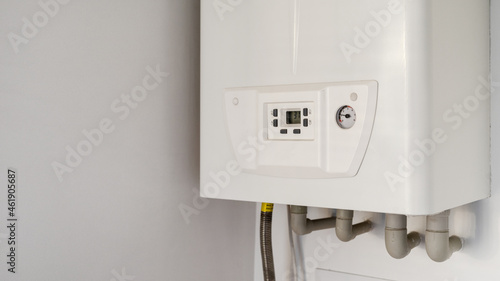 White modern gas water heater at the kitchen closet photo
