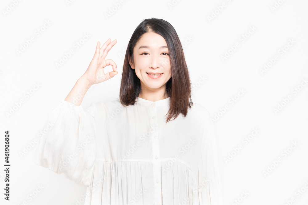白背景の前でOKのサインをする女性