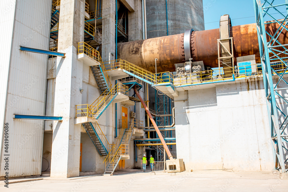 Naklejka premium Cement factory. Pipes and compressors, equipment, metalurgy. Modern technologies work at a cement plant. Technological work on the production of cement. Working atmosphere with copy space.
