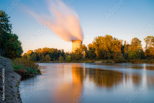Blick auf das AKW, Atomkraftwerk, Kernkraftwerk Gundremmingen mit Kühlturm und Verdunstungswolke vor blauem Himmel, warme Farben © JM Soedher