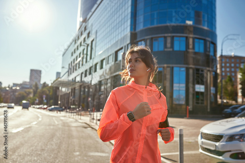 Active woman in headphones sportswear run outdoors