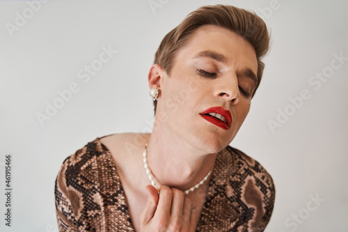 Womanlike man opened his mouth sensitively while posing at the female clothes photo