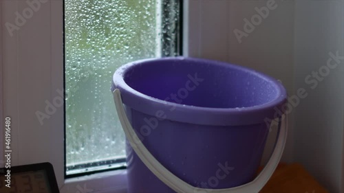 Wallpaper Mural Roof or balcony is leaking due to heavy rain, drops drip into bucket. Close-up. Concept of emergency condition of housing, breakdowns, repairs. Hand-held shooting with subsequent stabilization Torontodigital.ca