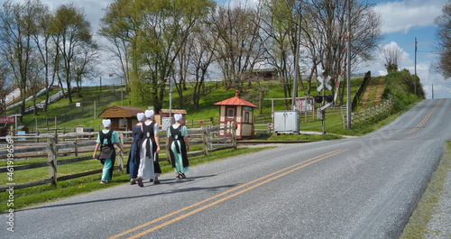 Teenage Amish Boys and Girls Walking Along a Rural Road in the Countryside on a Spring Day