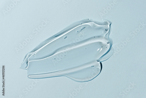 Liquid gel smear isolated on blue background. Beauty cosmetic smudge such as pure transparent aloe lotion, facial jelly serum, cleanser, shower gel or shampoo top view