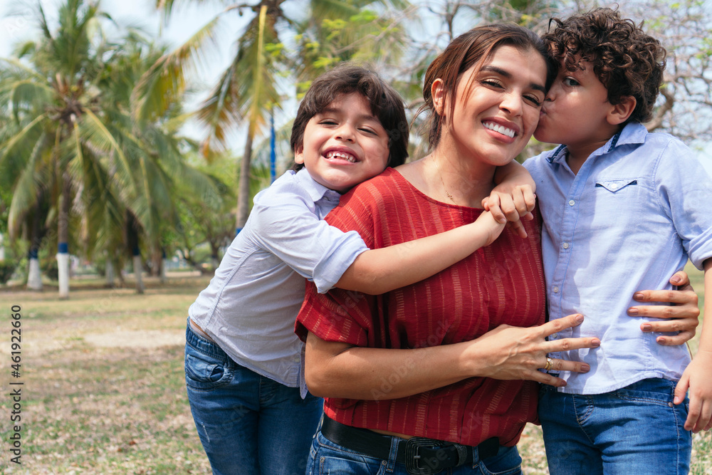 Hispanic mother and her young children playing in the park. Hispanic mother and her young children playing in the park.