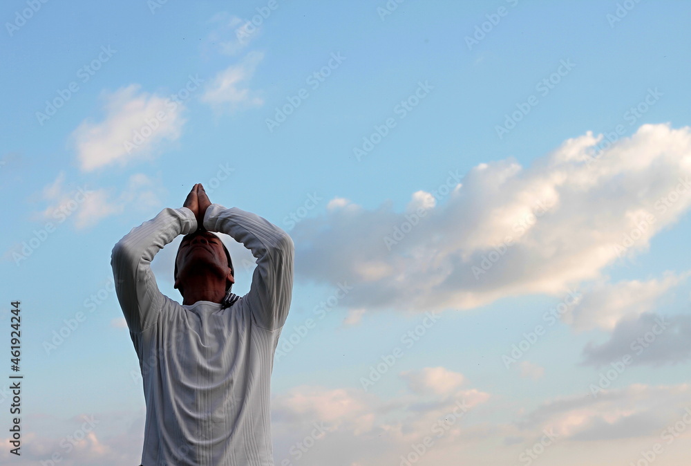 man praying to god with arms outstretched looking up to the sky stock photo man praying to god with arms outstretched looking up to the sky stock photo
