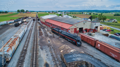 Strasburg, Pennsylvania, June 2021 - Aerial View of a Freight Yard With An Antique Steam Engine and Freight and Engine Shops