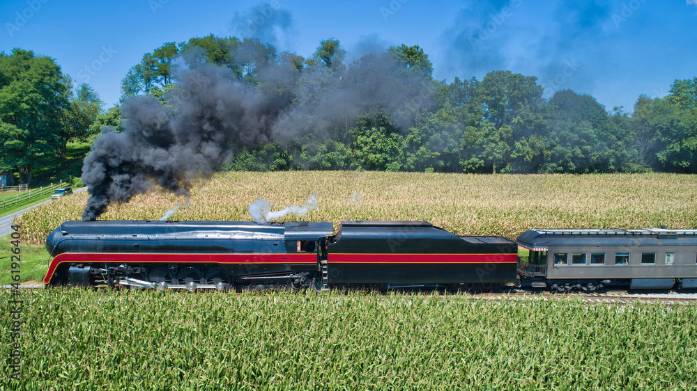 An Aerial View of an Antique Restored Steam Engine Blowing Smoke and Steam With a Passenger Coach An Aerial View of an Antique Restored Steam Engine Blowing Smoke and Steam With a Passenger Coach