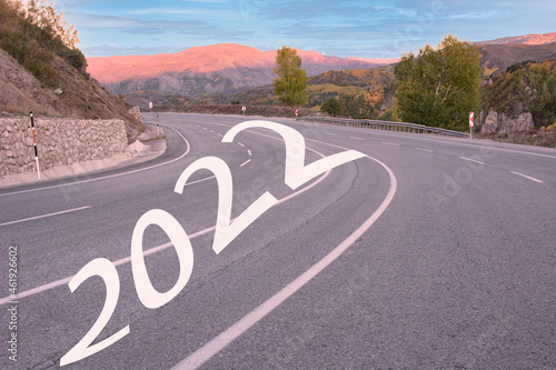 Start 2022 written on highway road in the middle of empty asphalt road and beautiful blue sky. Concept for vision new year 2022.