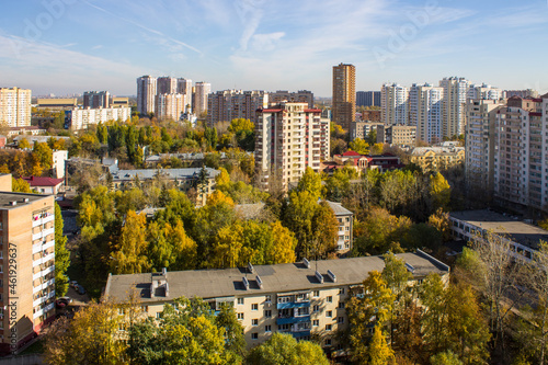 Cityscape - panoramic view of modern multi-storey buildings and colorful autumn trees on a sunny, clear day in Reutov, Russia.