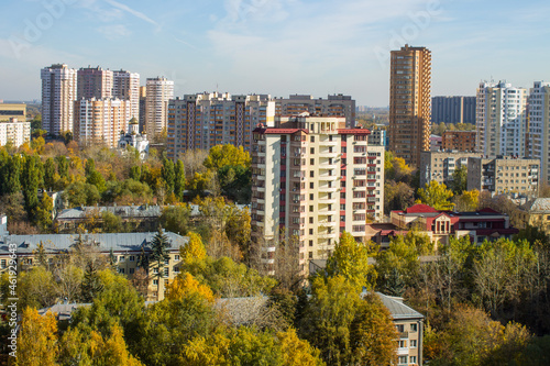Panoramic top view of modern city houses among autumn trees with colorful foliage and blue sky on a clear October day. Concept urban landscape in Reutov  Moscow region and copy space