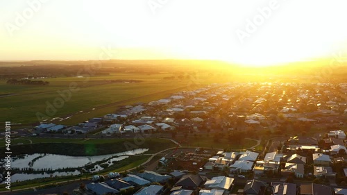 AERIAL Pedestal Down Bright Golden Sunrise Over Ocean Grove, Australia photo