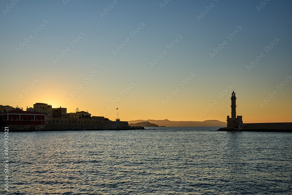 An ancient lighthouse at sunset in the port of Chania on the island of Crete