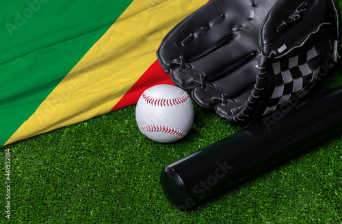 Baseball bat, glove and ball near Congo republic flag on green grass background