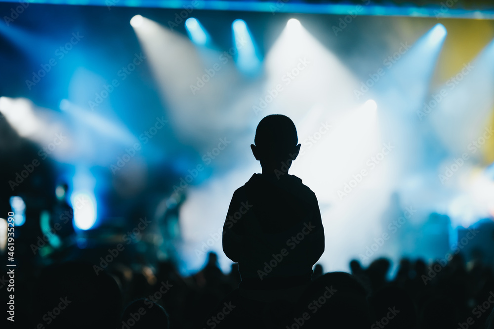 Child in a audience crowd having fun and enjoying concert on a festival