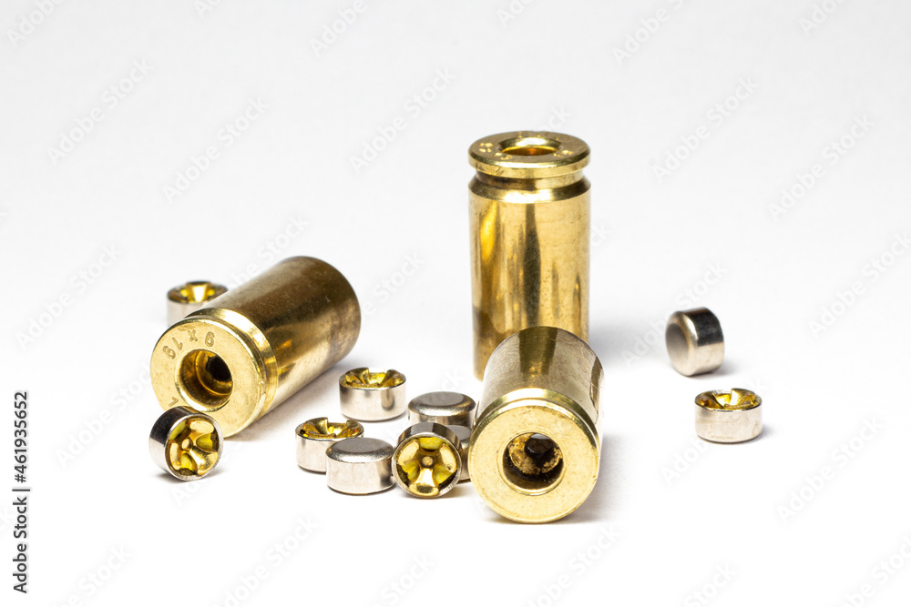 Reloading/handloading - closeup of decapped and cleaned 9mm Brass/casing  primer pockets and small pistol primers. Stock Photo