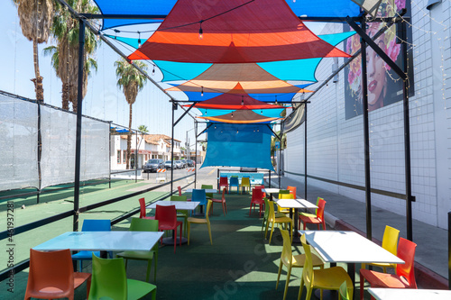 San Diego, California, USA - August 8, 2021: Colorful fabric shades on outdoor restaurant with chairs and tables. Empty seats outside