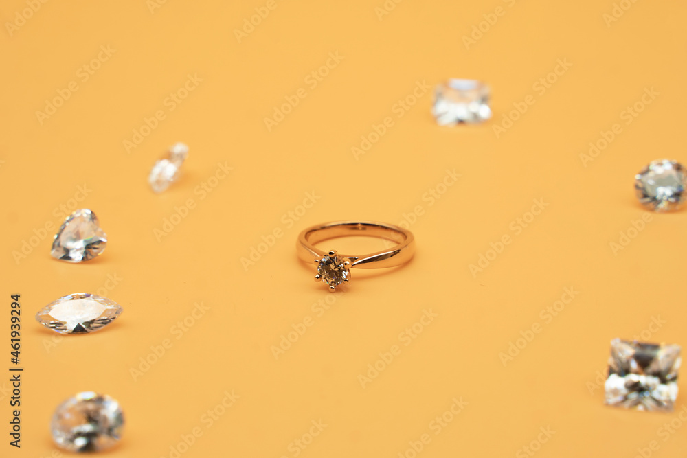 gold ring surrounded by diamonds on the yellow background