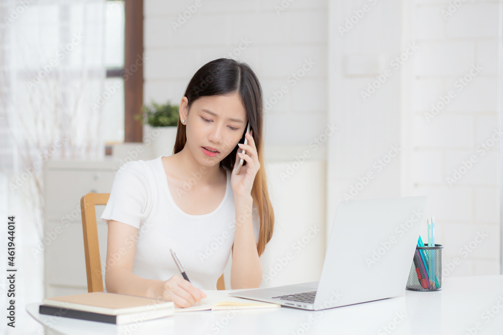 Young asian woman working on laptop computer and talking smartphone having stress and upset at home, girl having problem and worried, frustrated and unhappy, business and communication concept. Young asian woman working on laptop computer and talking smartphone having stress and upset at home, girl having problem and worried, frustrated and unhappy, business and communication concept.