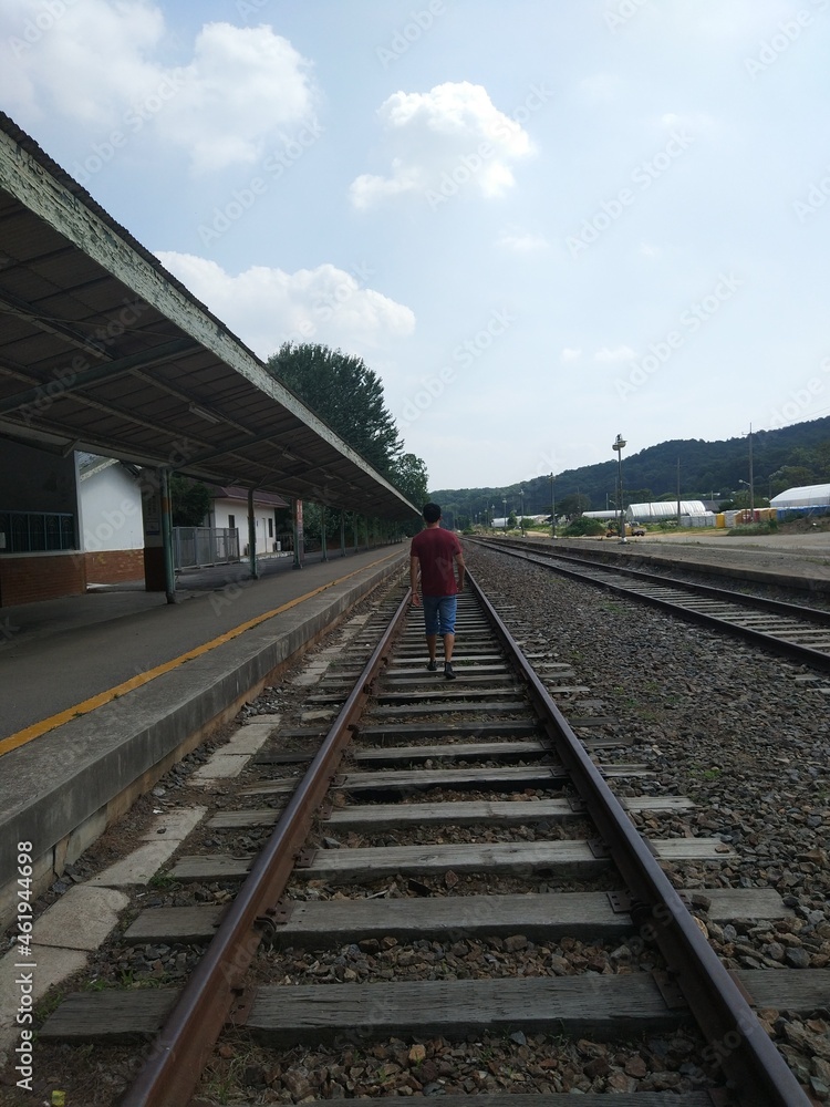 Man walking down train tracks perspective shot in Iryeong Station in South Korea